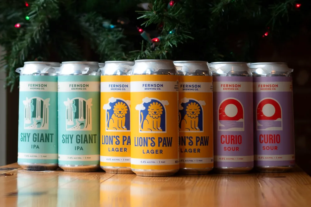 Cans of Shy Giant, Lion's Paw and Curio on a bar