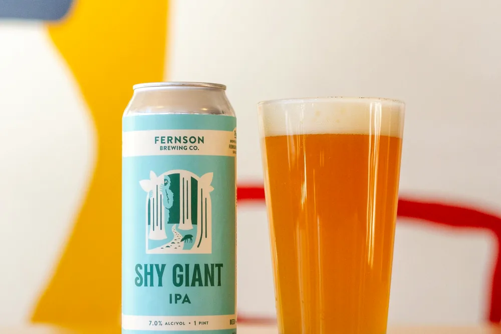 A can of Shy Giant IPA poured into a glass